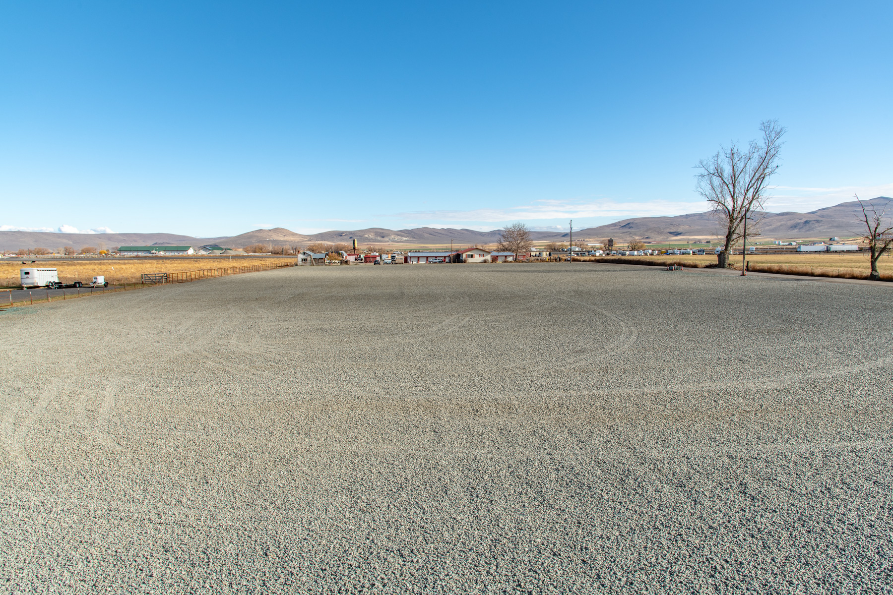 Graveled parking area with ample room for semi trucks and trailers.