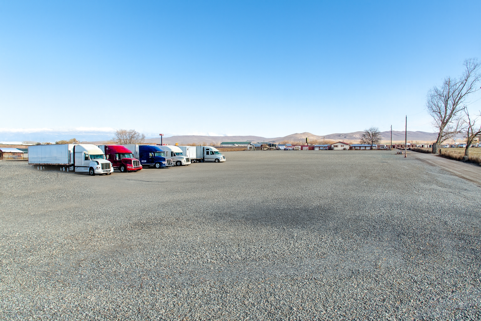 Commercial trucks and trailers parked on the lot.
